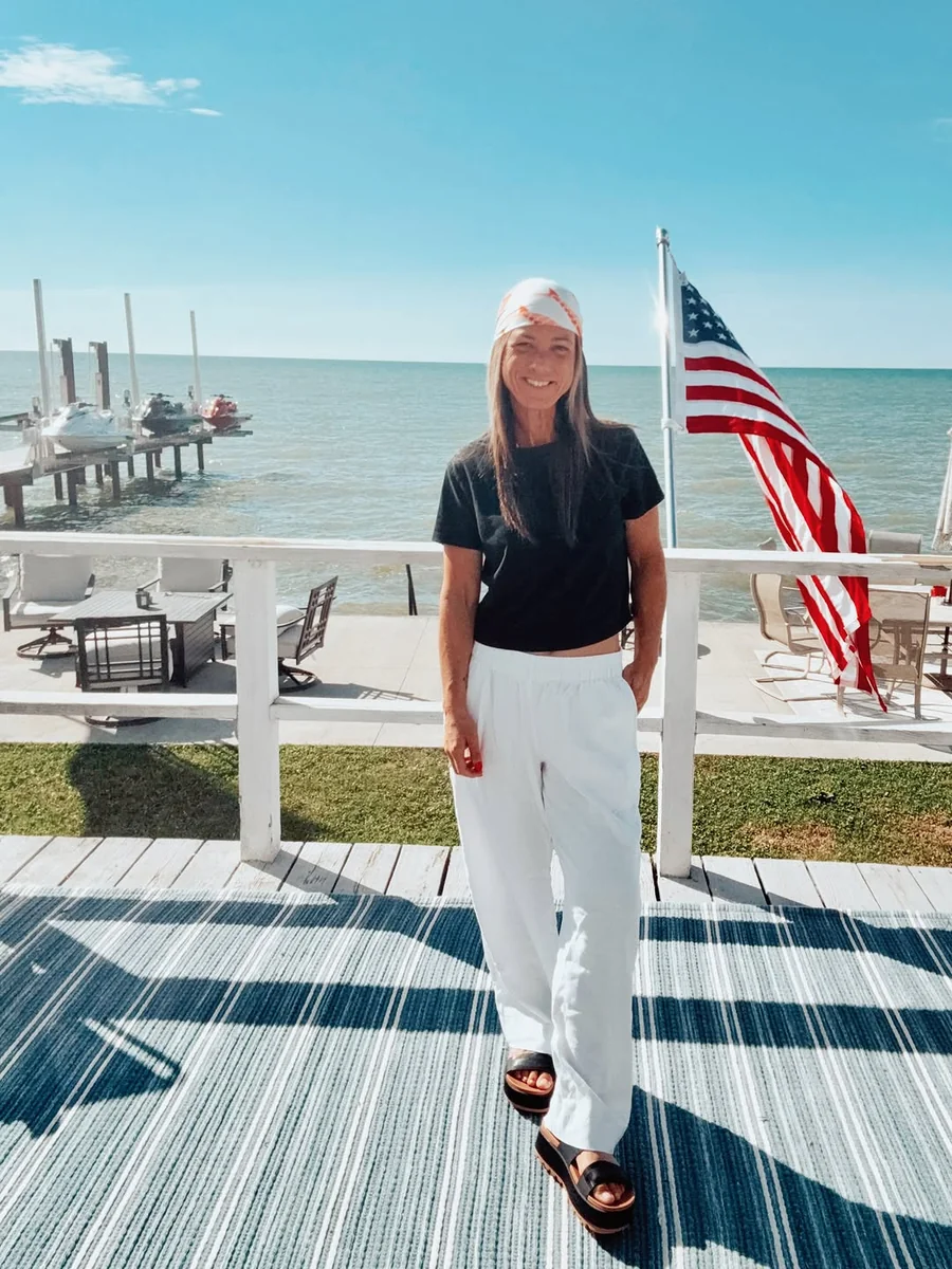 Coastal Contrast: Black Top, White Trousers on a petite woman