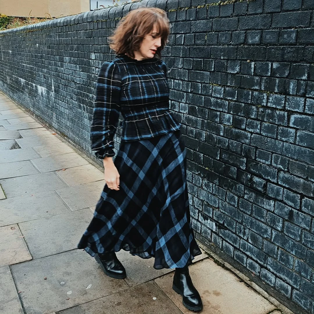 The Gray Cardigan and Plaid Skirt on a petite woman