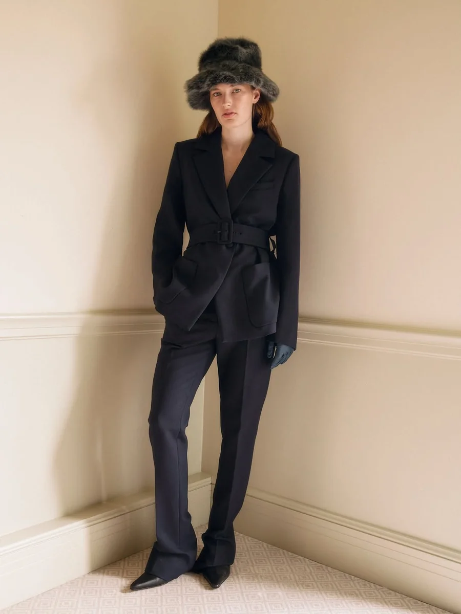 A Navy Belted Suit Finished With a Stylish Hat on a petite woman