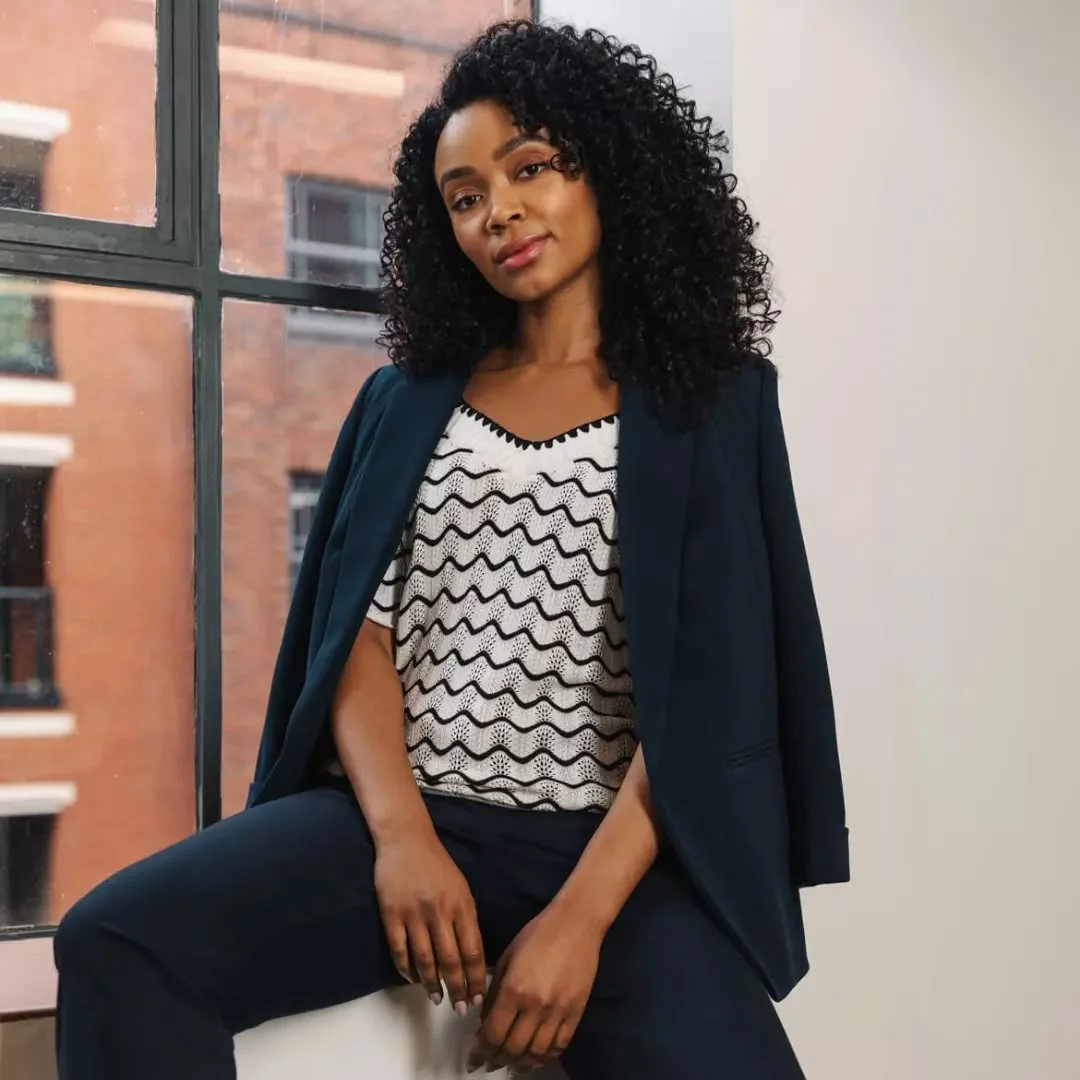Navy Blazer Over a Zigzag Knit Top on a petite woman
