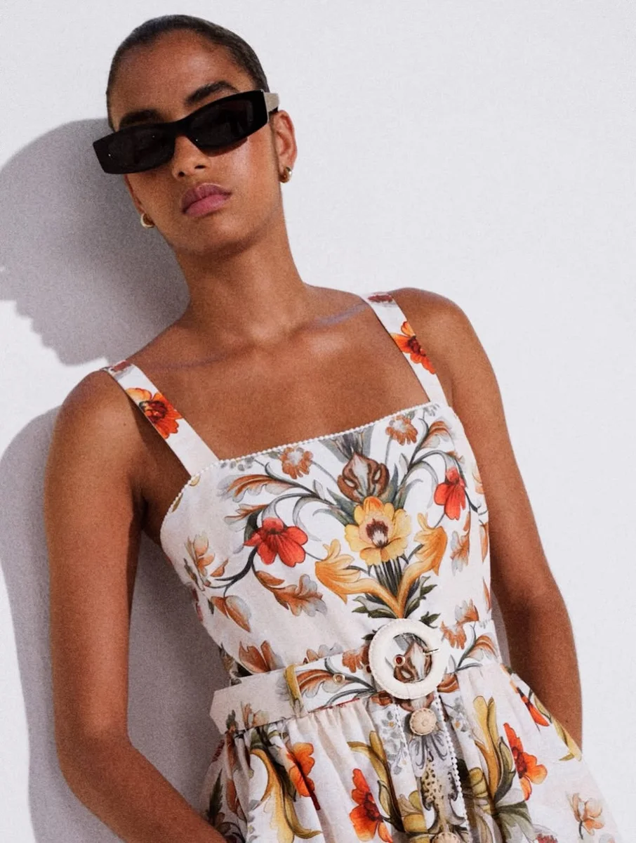 A Square-Neck Floral Mini with a Statement Belt on a petite woman