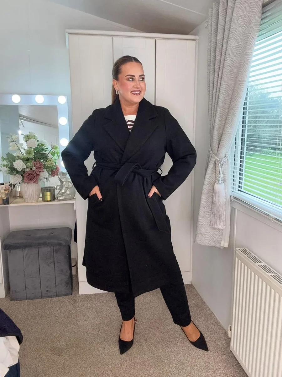 The Belted Black Wrap Coat Formula on a petite woman
