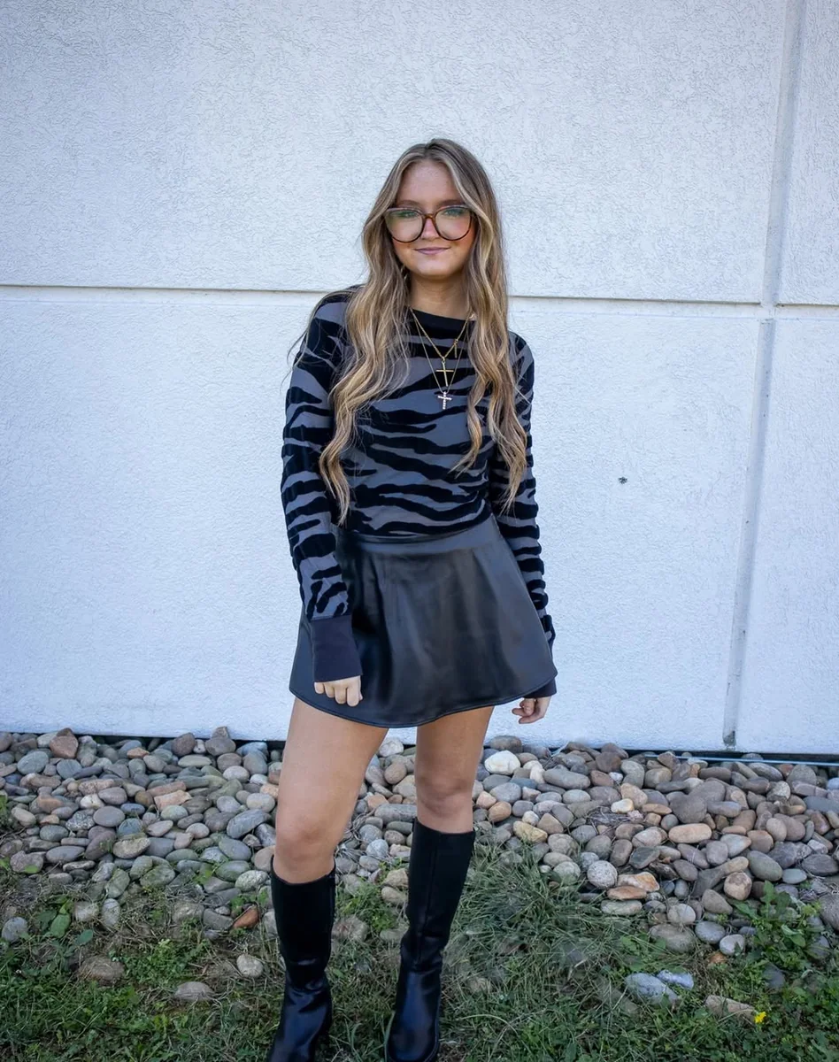 Zebra Top, Pleated Mini, Knee Boots on a petite woman
