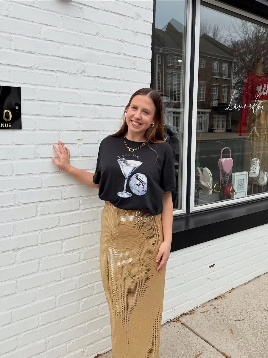 Graphic Tee Tucked Into a Gold Sequin Maxi on a petite woman